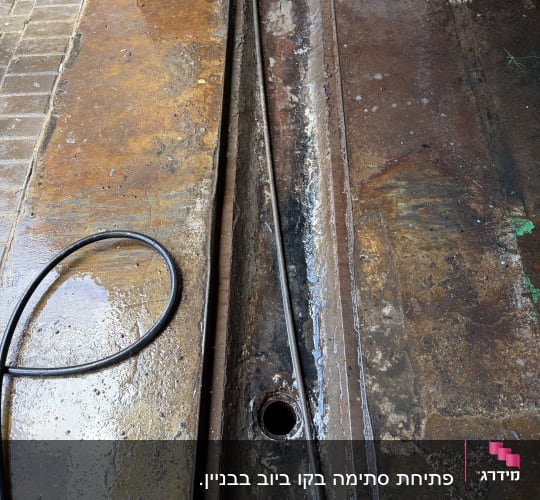 תעלת ניקוז עם צינור ומים על הרצפה